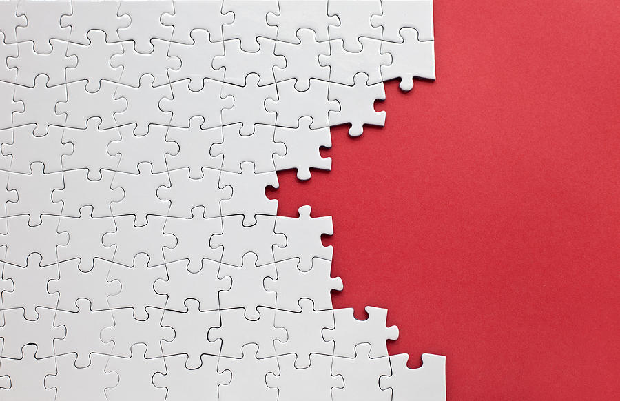 White jigsaw puzzle on a red background Photograph by MerveKarahan