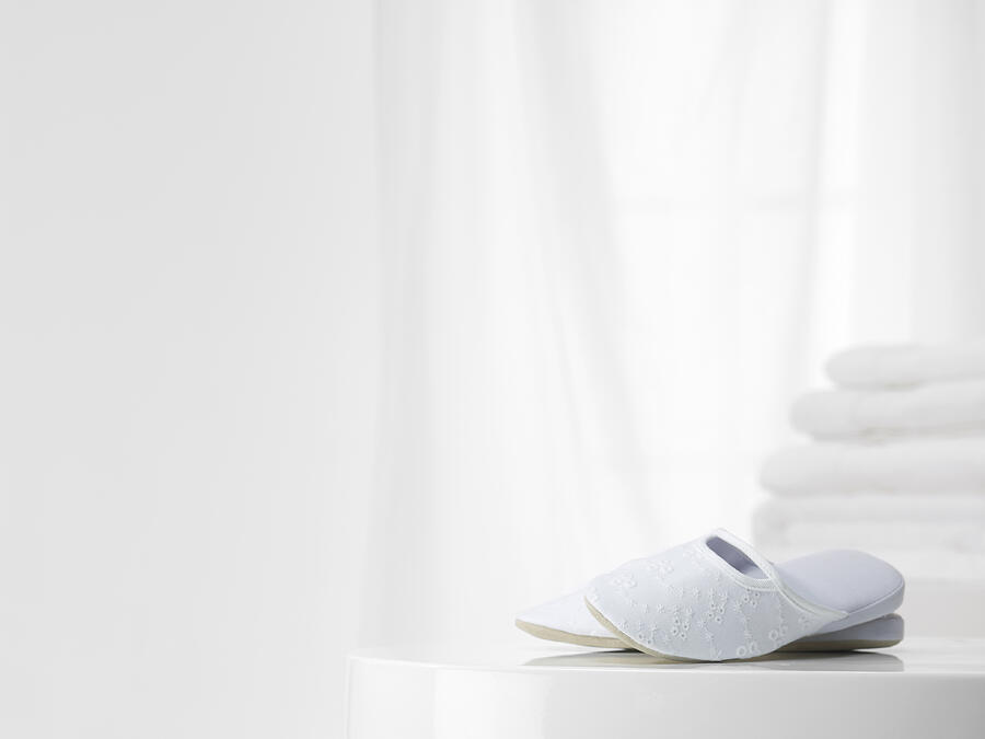 White slippers with white towles in the background Photograph by Will Woods