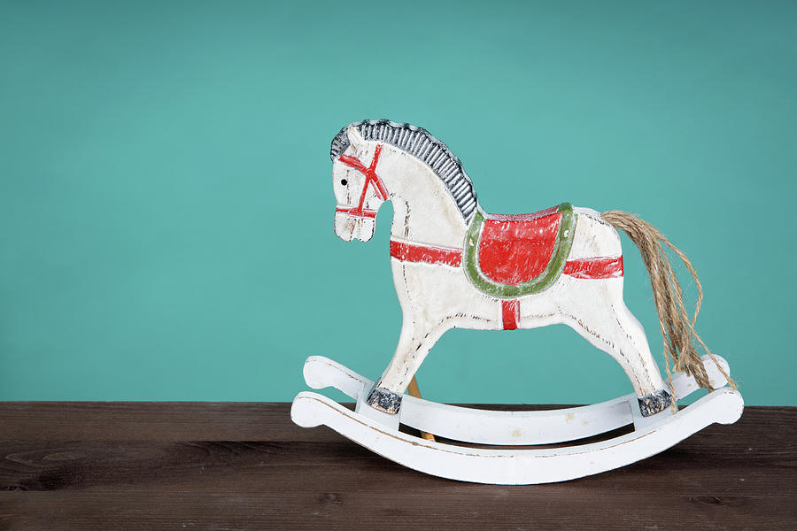 White Vintage Rocking Horse On Wooden Floor. Green Background Photograph