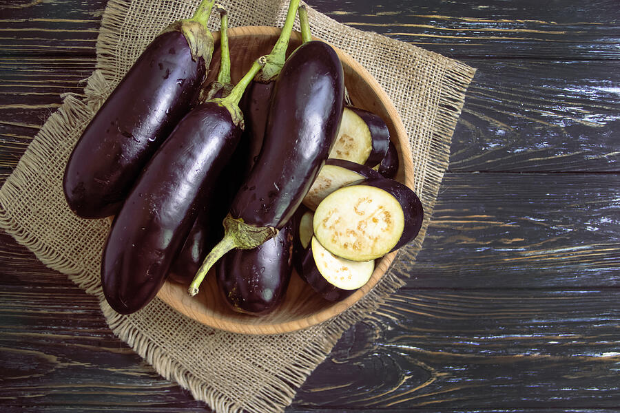 Whole Eggplant On Wooden Background Photograph by TanyaLovus