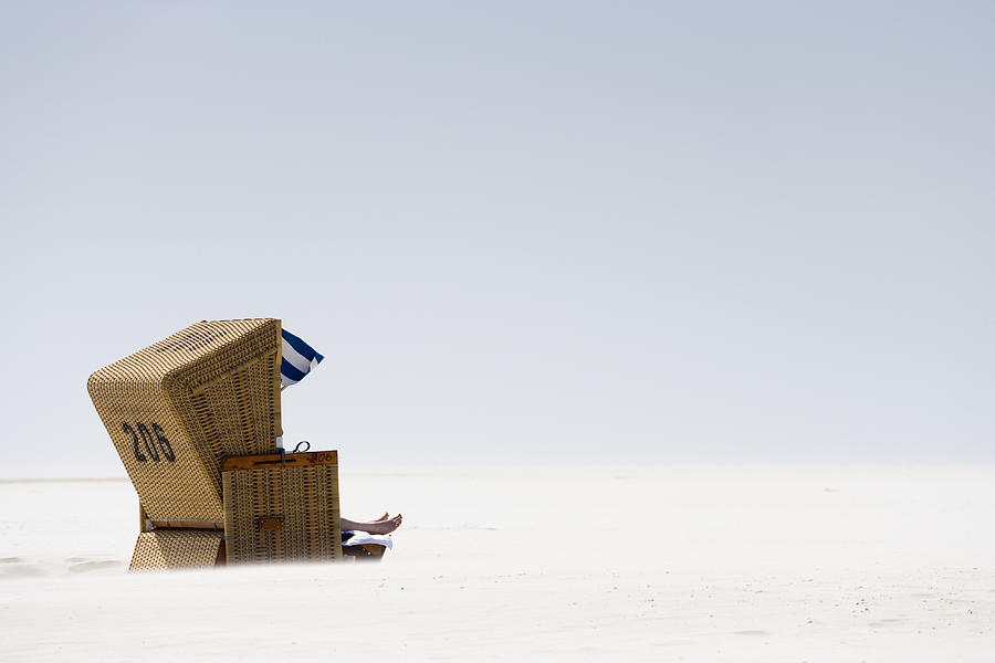 Wicker chair on beach Photograph by Jorg Greuel