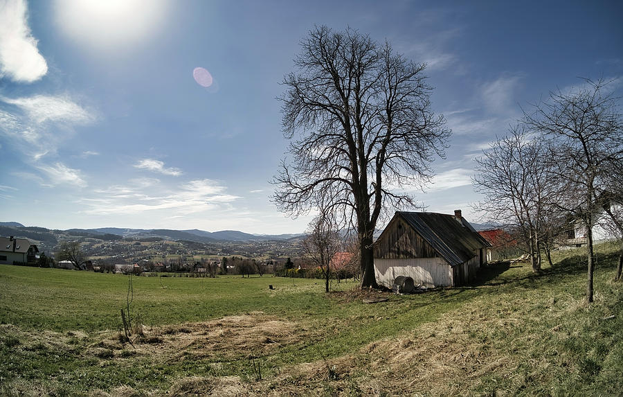 Wide angle shot of an abandoned A shaped house next to leafless tree against mountain hills and blue sky located in Limanowa, South Poland Photograph by Arpan Bhatia