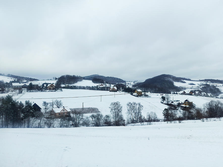 Wide angle shot of small polish town covered with white snow and houses against small mountains in southern Poland located the Lesser Poland Voivodeship. Winter scenery of Central Europe. Photograph by Arpan Bhatia