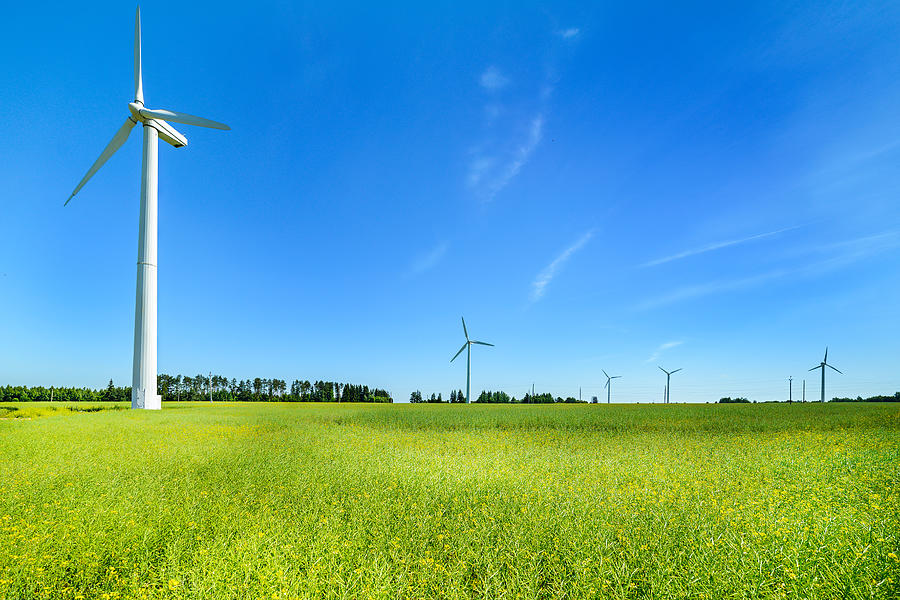 Wind generator in the meadows, on a background of blue Photograph by Nordroden