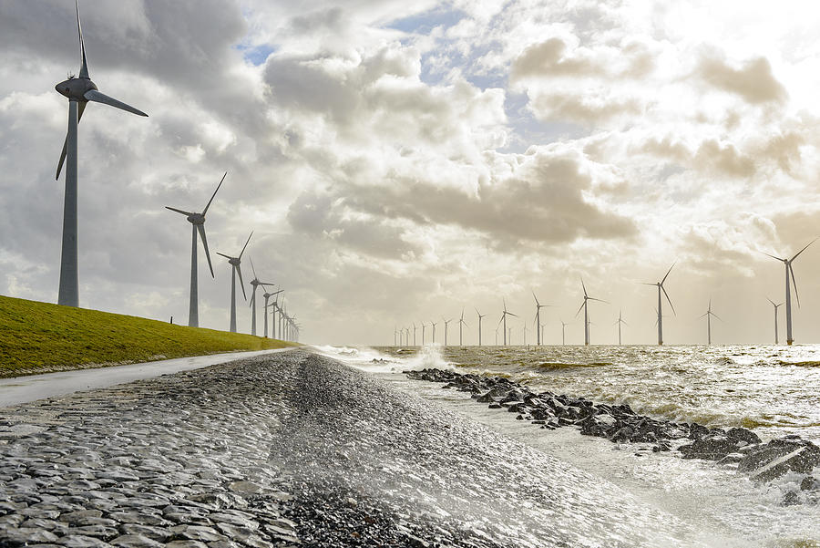 Wind turbines on land and offshore in a storm Photograph by Sjo