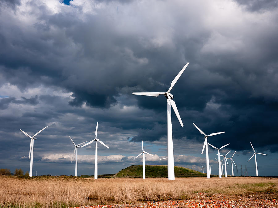 Wind turbines photographed against a dark, stormy sky Photograph by Jorgenjacobsen