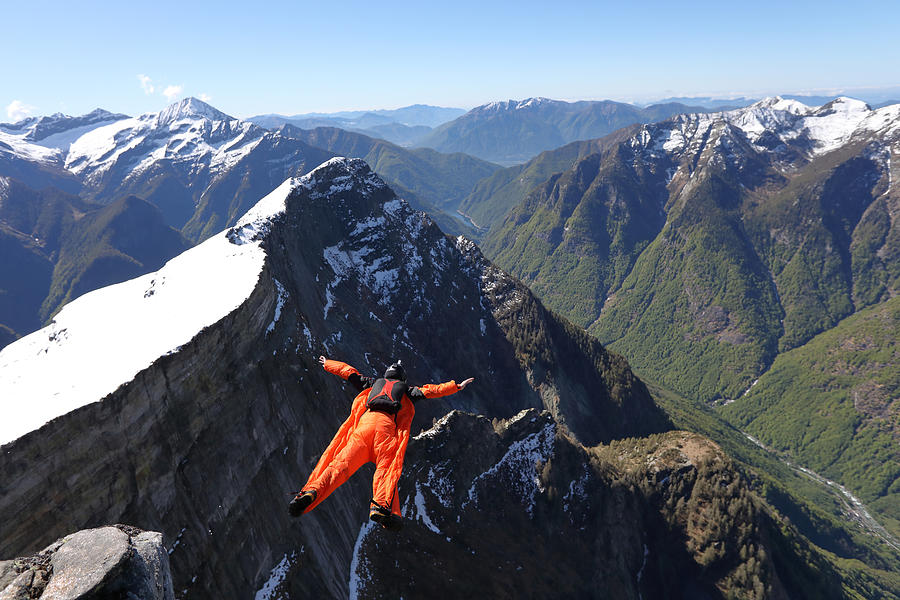 Wingsuit flyer airbourne above mountains Photograph by Ascent/PKS Media Inc.