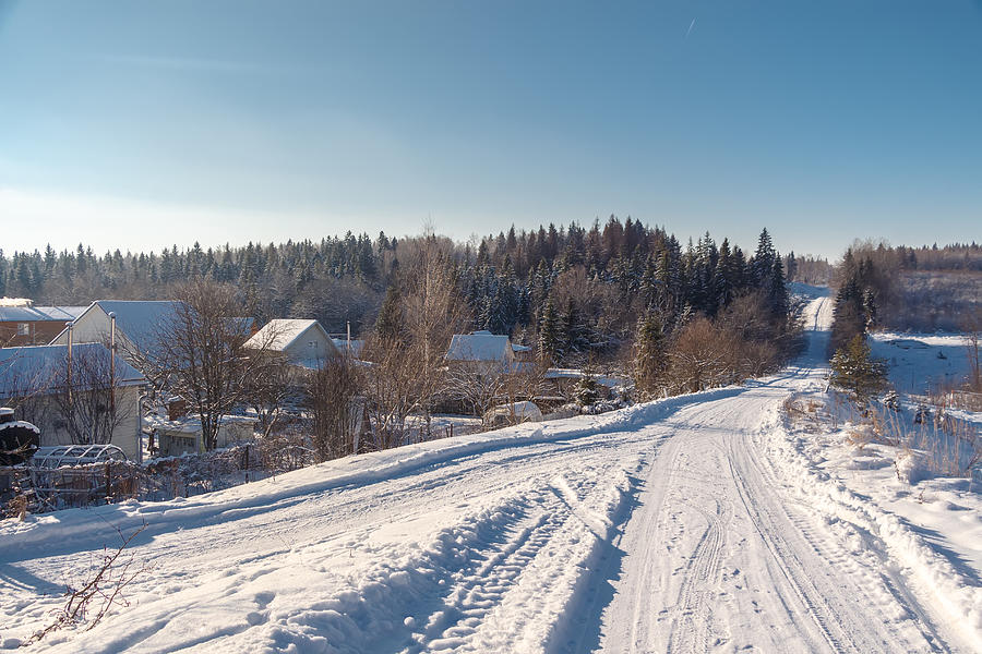 Winter country road and village. Photograph by Masterovoy
