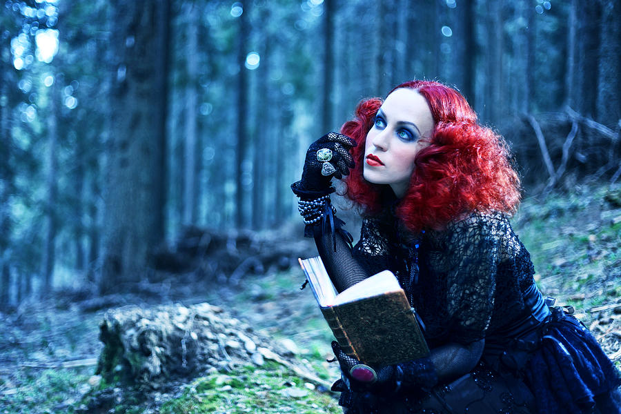 Witch in the forest rading book. Halloween theme Photograph by Valentinrussanov