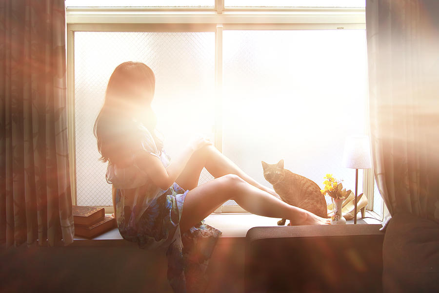 Woman and cat by the window. Photograph by YuriF
