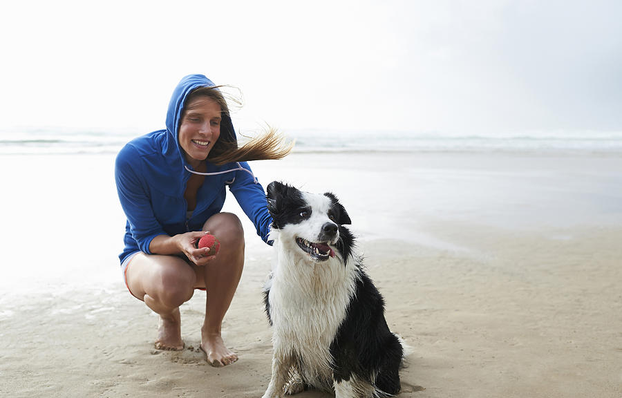 Woman and dog on beach. Photograph by Dougal Waters