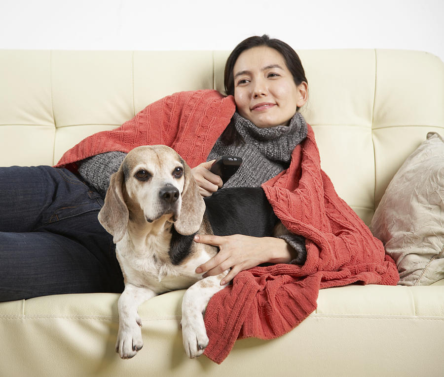 Woman and dog relaxing on sofa Photograph by Nora Tejada