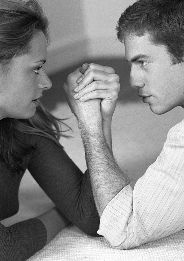 Woman and man arm wrestling, close-up, b&w Photograph by Clara Neuimie