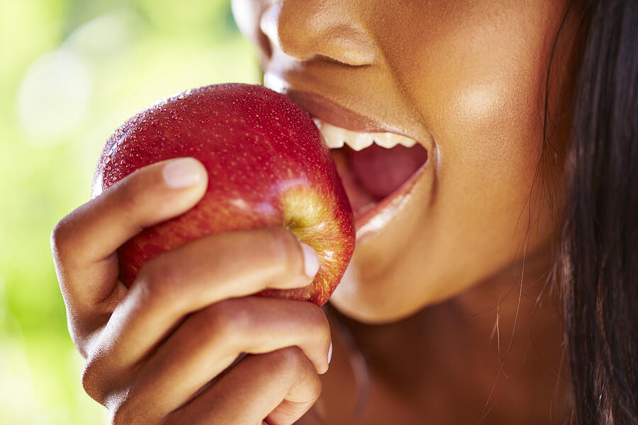 Woman biting red apple, close-up Photograph by Westend61