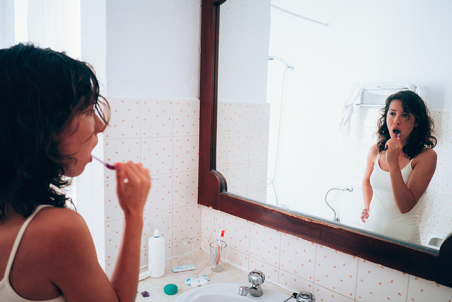 Woman brushing her teeth Photograph by Photo by Rafa Elias