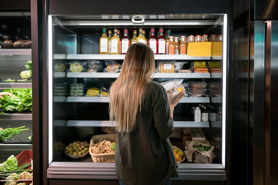 Woman buying food at the supermarket Photograph by Andresr