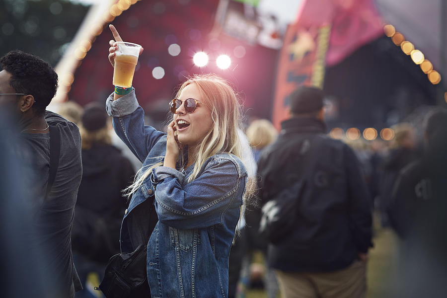 Woman cheering with beer at concert Photograph by Klaus Vedfelt