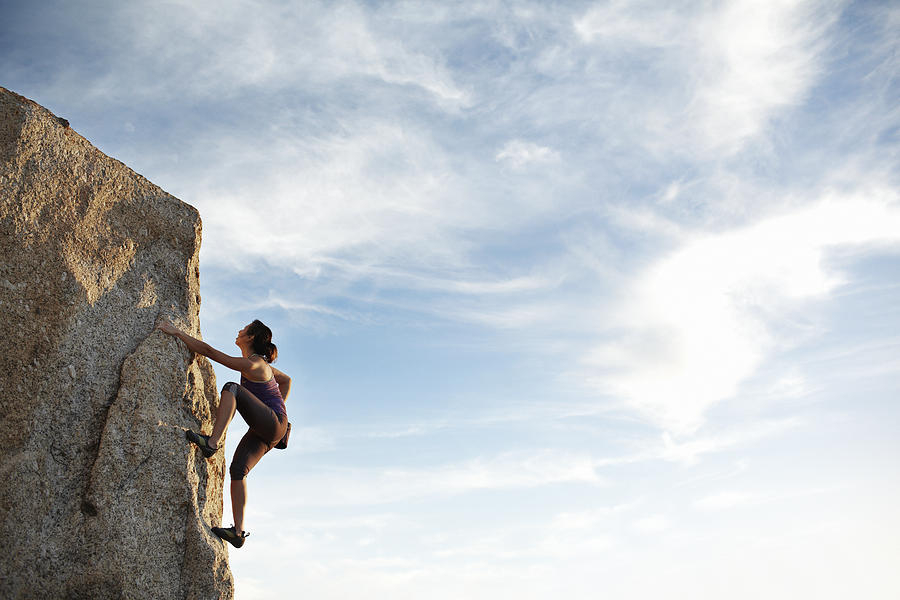 Woman climbing rock side Photograph by Klaus Vedfelt