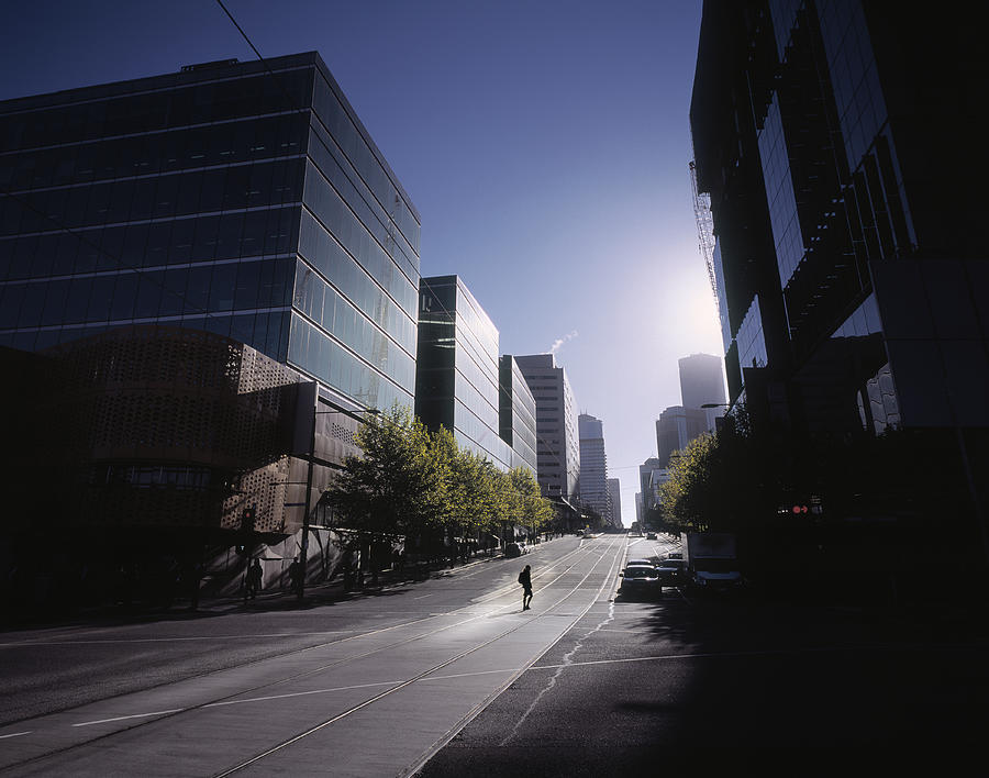 Woman crossing empty street in Melbourne at dawn Photograph by EschCollection
