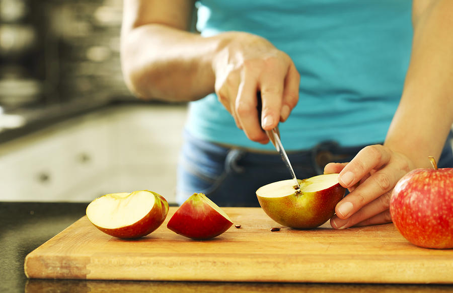 Woman cutting fresh apples Photograph by Anjelika Gretskaia