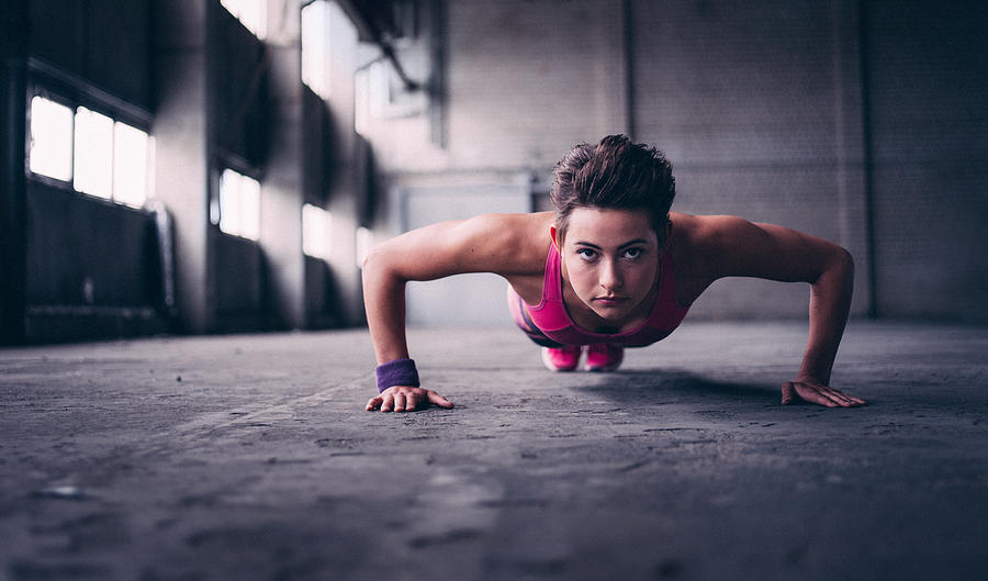 Woman doing push ups with determination in  industrial space Photograph by Wundervisuals