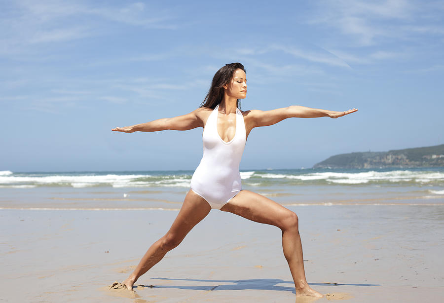 Woman doing yoga on Australian beach, Warrior Pose Photograph by Wander Women Collective