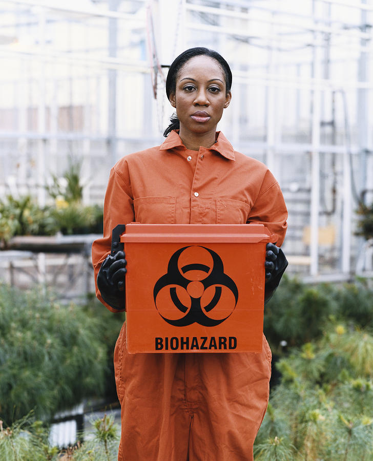 Woman Dressed in Protective Clothing Holding a Hazardous Box in a Greenhouse Photograph by Noel Hendrickson