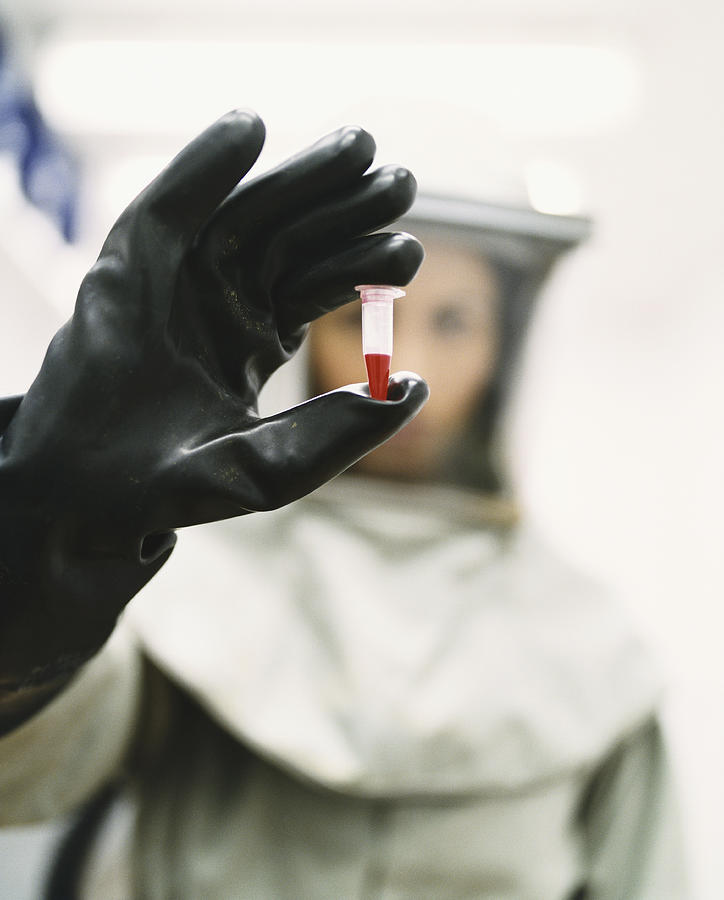 Woman Dressed in Protective Mask and Clothing and Holding a Blood Sample Photograph by Noel Hendrickson