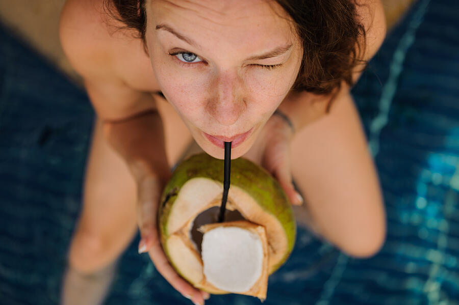 woman drinking coconut . Happy carefree freedom girl in summer day. Photograph by MaximFesenko