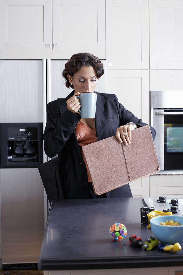 Woman drinking coffee in kitchen Photograph by Sean Justice