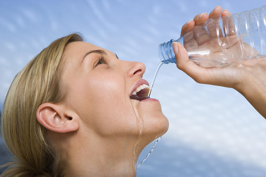 Woman drinking water Photograph by Jupiterimages Woman drinking water Photograph by Jupiterimages
