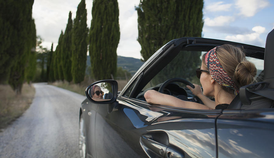 Woman driving convertible car on Tuscan country road, Italy Photograph by Kathrin Ziegler