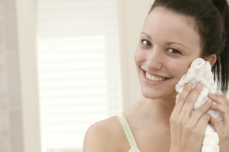 Woman drying face with towel Photograph by Comstock Images