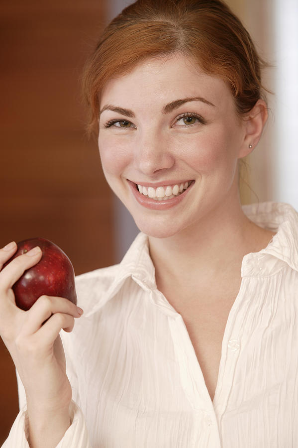 Woman eating apple Photograph by Comstock Images