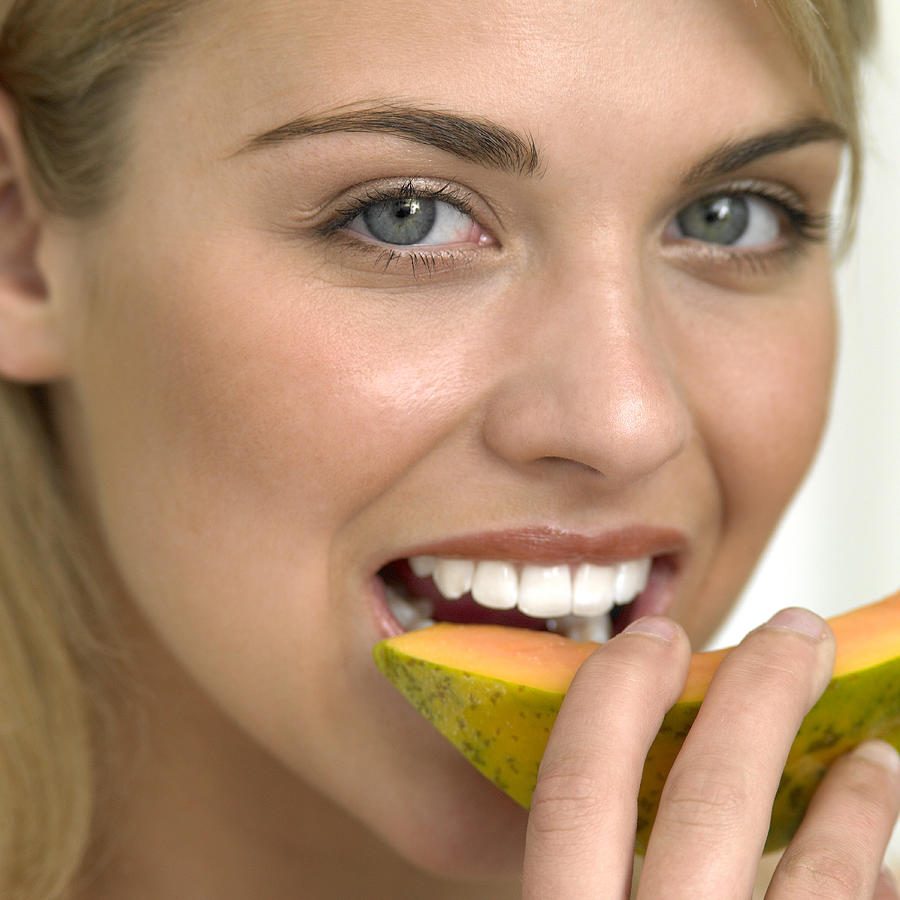 Woman eating melon, portrait Photograph by Smile