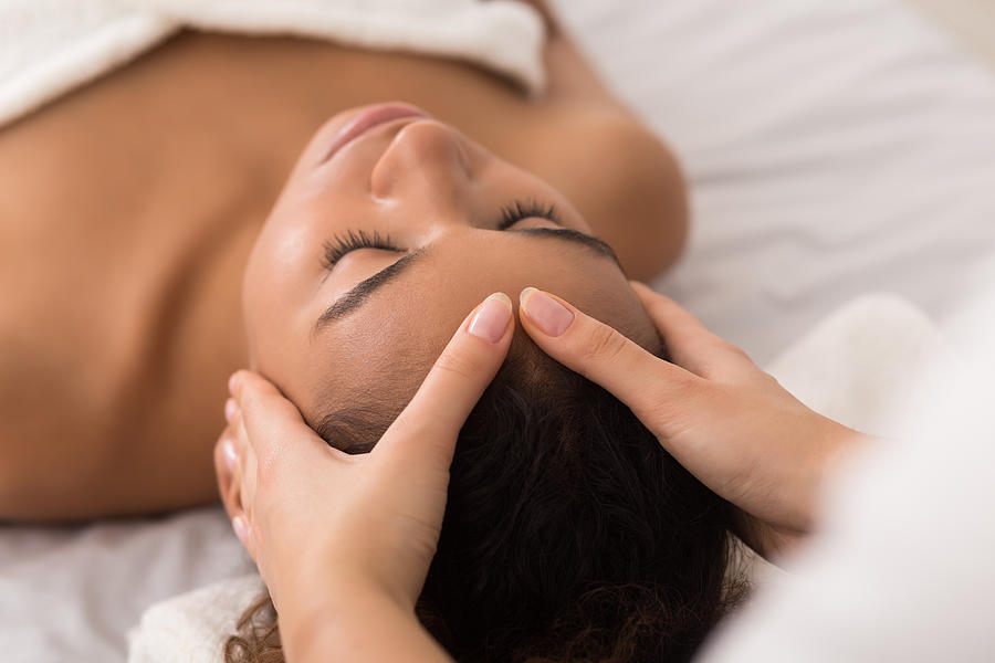 Woman enjoying anti aging facial massage in spa salon Photograph by Prostock-Studio