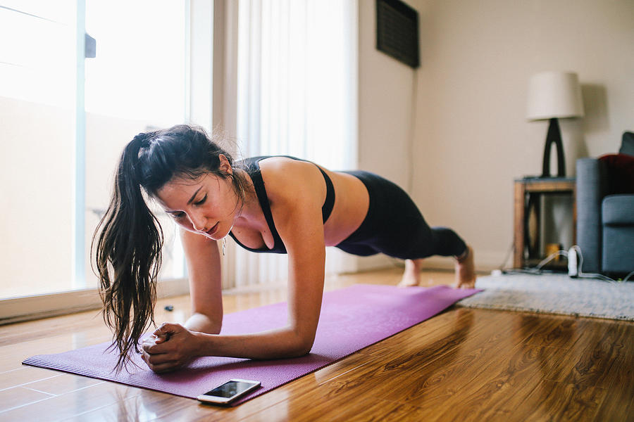 Woman exercising planks at home in Los Angeles Photograph by Lechatnoir