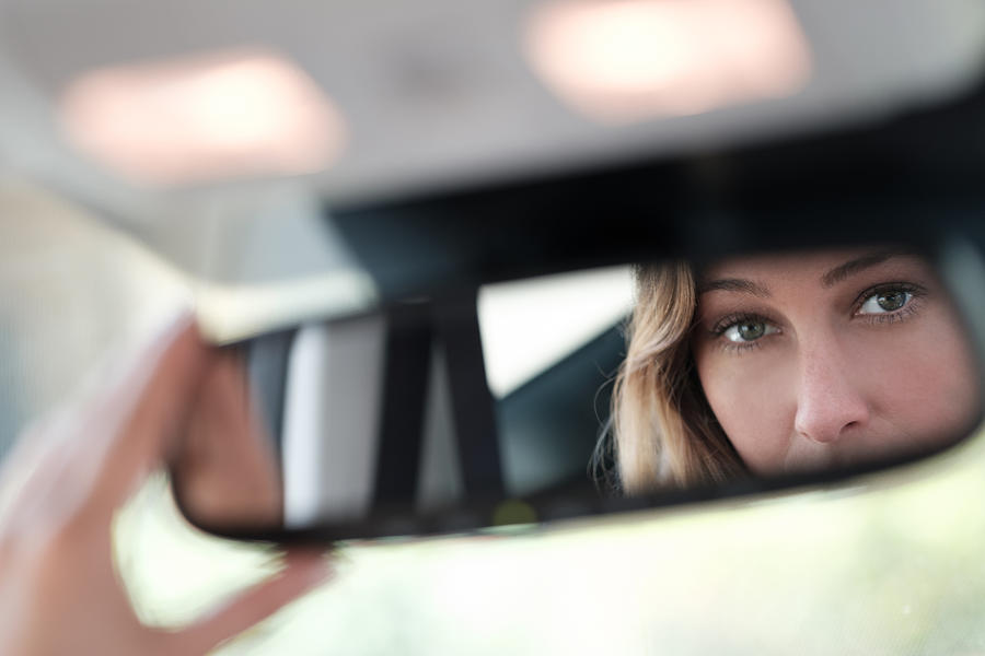 Woman face reflected in rearview mirror Photograph by Tetra Images
