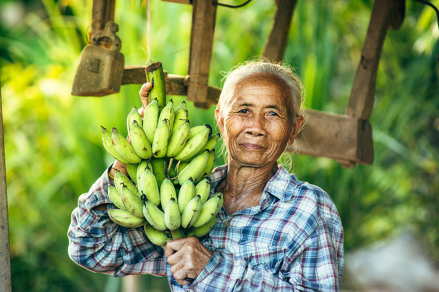 Woman farmer holding green banana Photograph by Visoot Uthairam