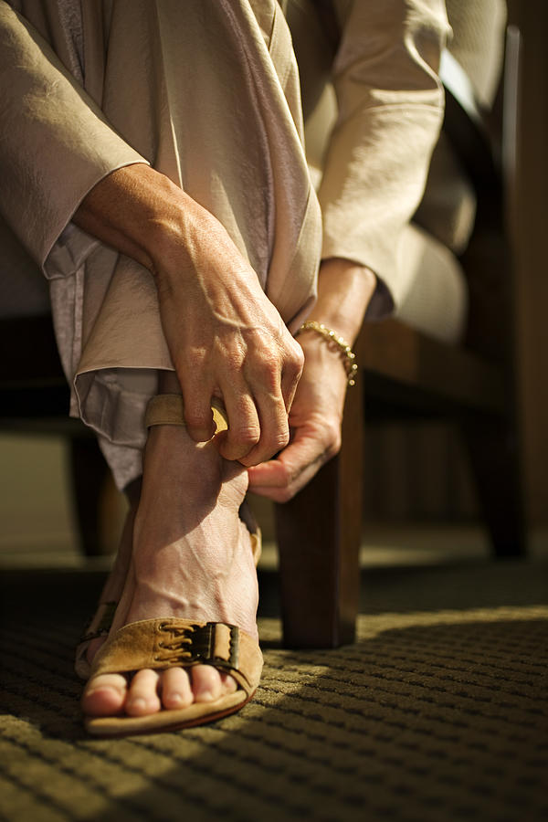 Woman fastening sandal Photograph by Thinkstock