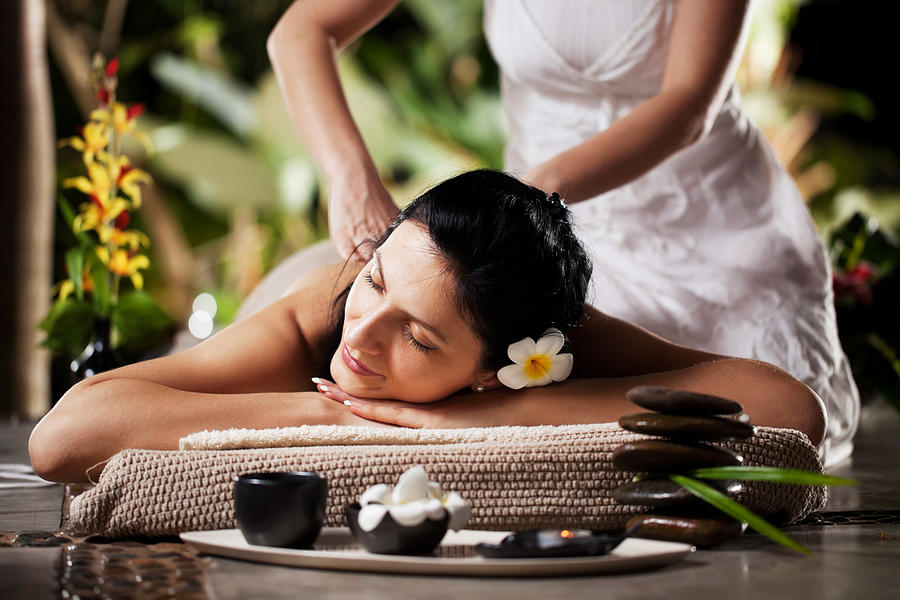 Woman getting a massage at tropical spa Photograph by Skynesher