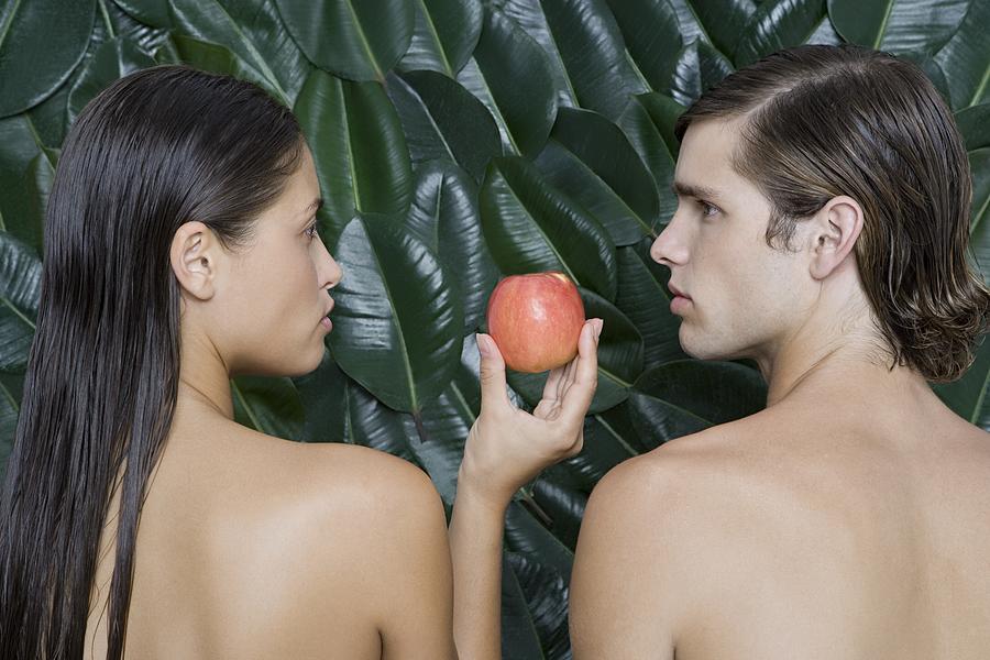 Woman giving man an apple Photograph by Image Source