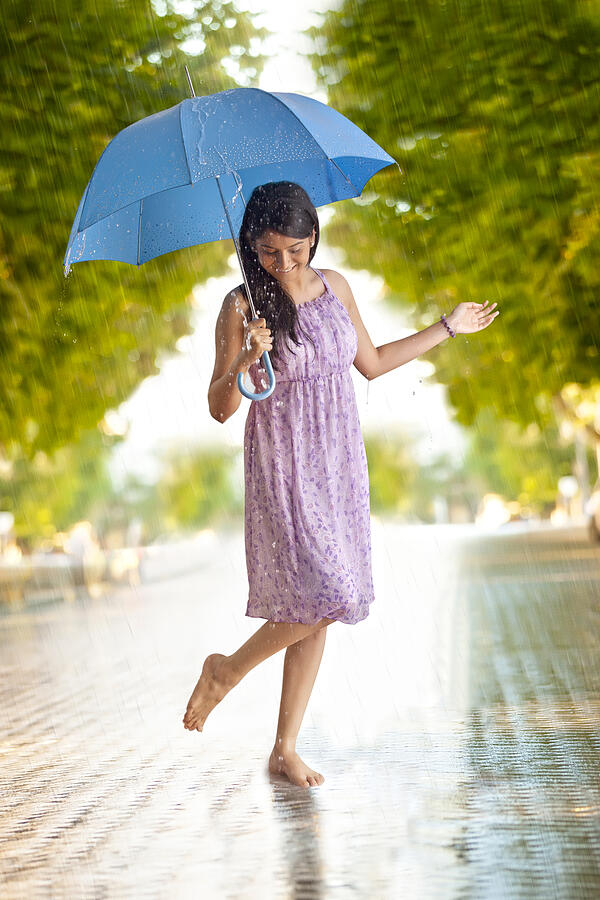 Woman having fun in the rain Photograph by IndiaPix/IndiaPicture