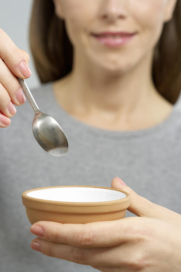 Woman holding a dish and a spoon Photograph by Stock4b-rf
