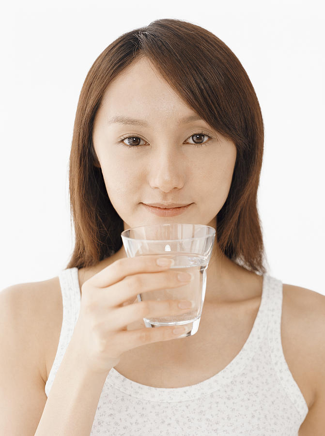 Woman Holding a Glass of Water Photograph by Digital Vision.