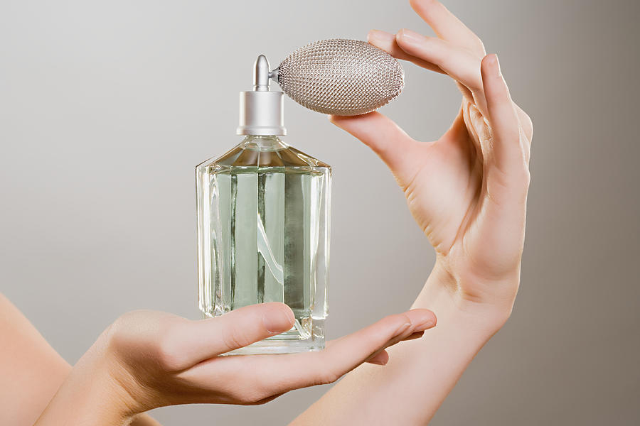 Woman holding a perfume bottle Photograph by Image Source