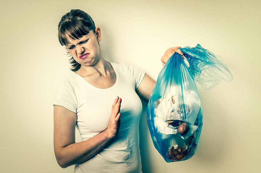 Woman holding a smelly garbage bag Photograph by Andriano_cz