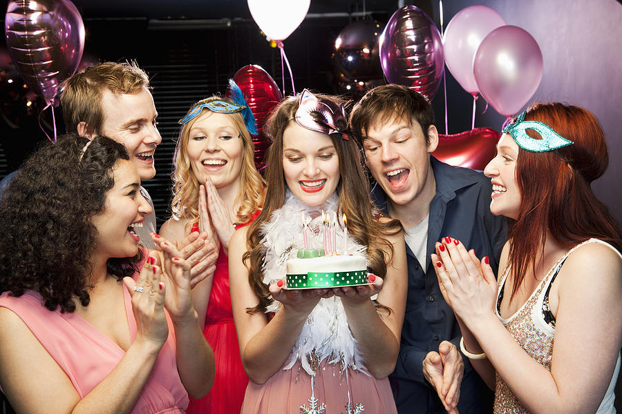 Woman holding birthday cake with friends around Photograph by Betsie Van Der Meer