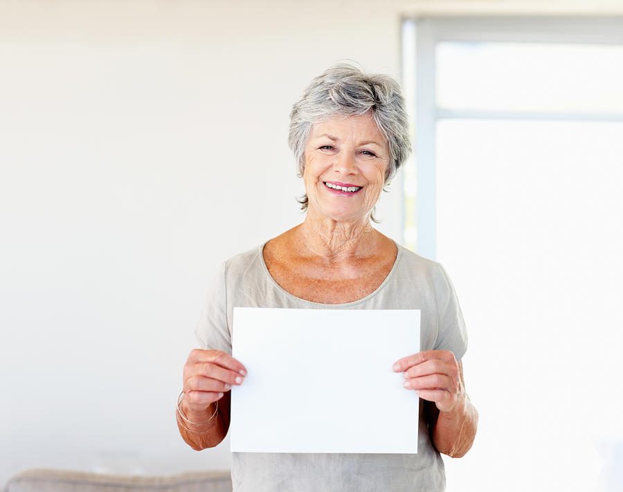 Woman holding blank sheet of paper Photograph by GlobalStock