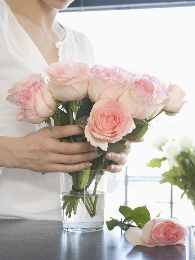 Woman holding bouquet of pink roses Photograph by Jupiterimages